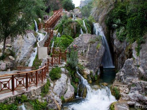 a waterfall at a restaurant next to a river at Villa Jacqueline la buena vida in Playa Flamenca
