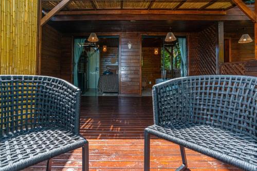 two wicker chairs sitting on the porch of a house at Nosso Mar in Florianópolis