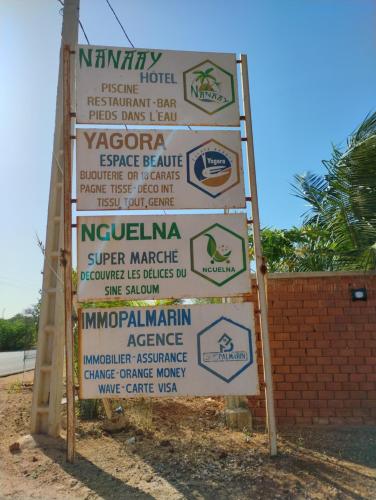 a large sign with a lot of signs on it at Hôtel Nanaay in Palmarin