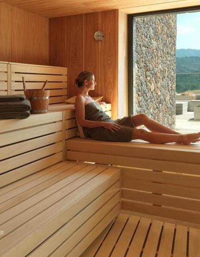 a woman sitting on a window sill in a sauna at Ampuria Inn in Empuriabrava
