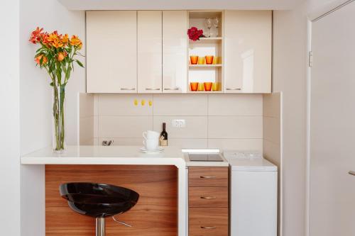 a kitchen with a black chair and a vase of flowers at Apartments Blue Sea in Kotor