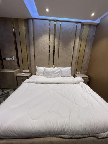 a large bed with white sheets and pillows at Courteous Hotel in Islamabad