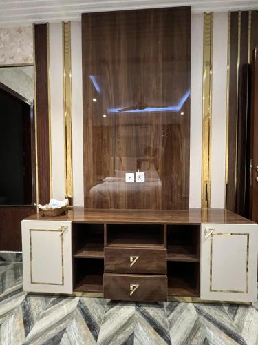 a room with a dresser with a bed in it at Courteous Hotel in Islamabad