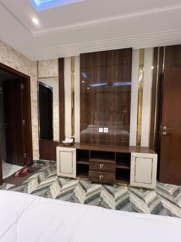 a living room with a dresser and a mirror at Courteous Hotel in Islamabad