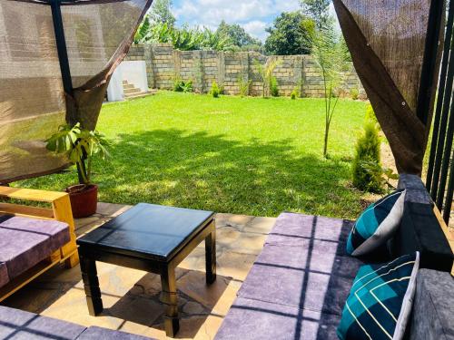 a patio with a hammock and a table and a yard at Larchwood House Tigoni in Nairobi