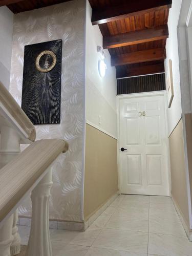 a hallway with a white door and a painting on the wall at HNH Hotel Luxury Experiencia Vip in San Andrés