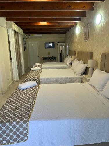 a group of four beds in a room at HNH Hotel Luxury Experiencia Vip in San Andrés