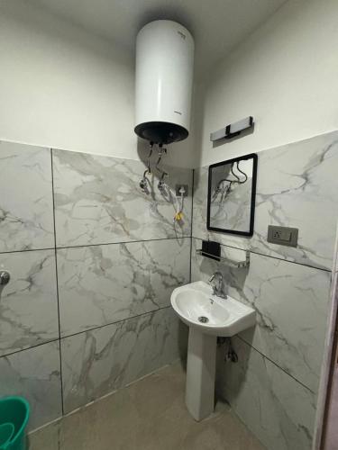 a bathroom with a sink and a marble wall at Arcane viewfinder homestay in Gangtok