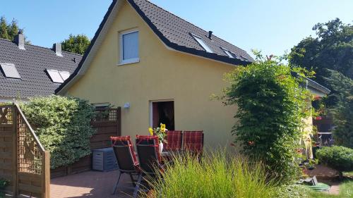 una casa gialla con un tetto nero e un patio di Sonnenblume - Sonne 2 rechts a Zingst