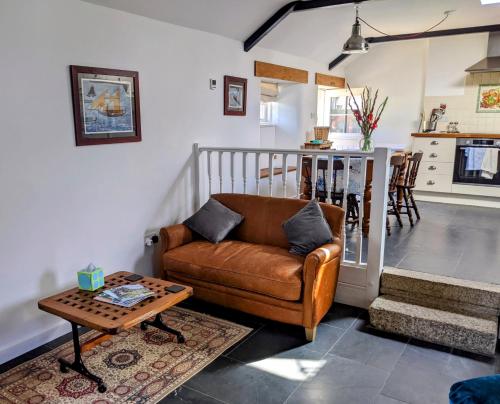 a living room with a couch and a table at Bleujenn barn, delightful home near stunning beach and walks in Penzance