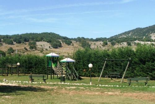 a park with a playground with benches and swings at Agriturismo Monte Sacro in Mattinata
