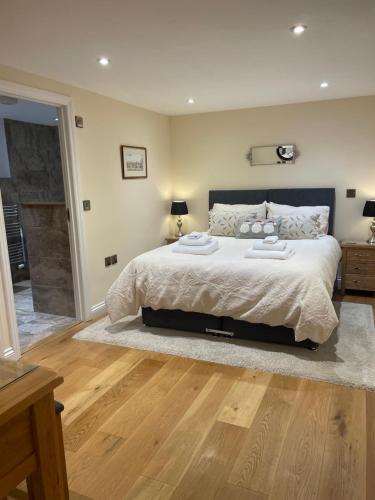 a bedroom with a large bed and a wooden floor at Little Howle Farm Barn in Ross on Wye