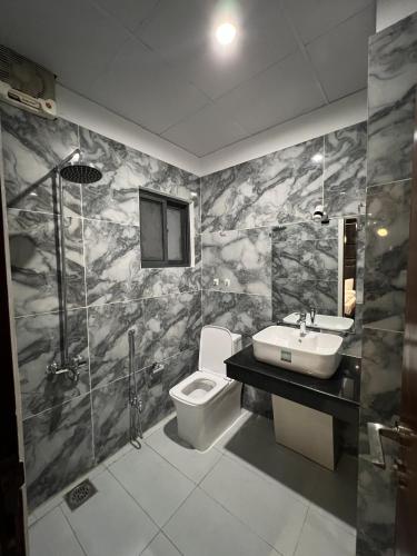 a bathroom with a toilet and a sink at Courteous Hotel in Islamabad