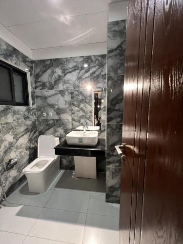 a bathroom with a sink and a toilet at Courteous Hotel in Islamabad