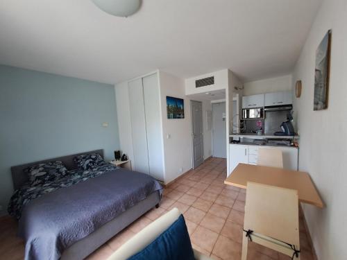 une chambre avec un lit et une table et une cuisine dans l'établissement Lalbatros, à Mouans-Sartoux