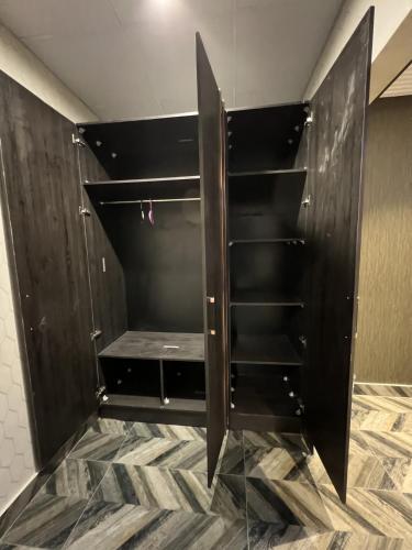 a walk in closet with black cabinets at Courteous Hotel in Islamabad