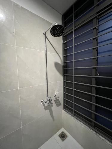 a shower stall in a bathroom with a window at Courteous Hotel in Islamabad