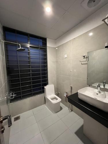a bathroom with a toilet and a sink and a mirror at Courteous Hotel in Islamabad