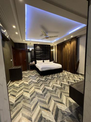 a large bedroom with a bed and a large carpet at Courteous Hotel in Islamabad