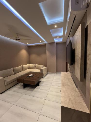 a living room with a couch and a tv at Courteous Hotel in Islamabad