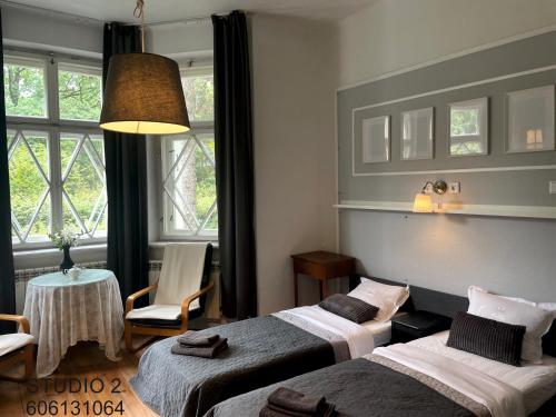 a hotel room with two beds and a table and chairs at Willa Dina in Milanówek