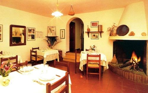 sala de estar con chimenea, mesa y sillas en Agriturismo Monte Sacro en Mattinata