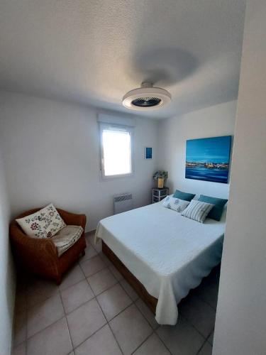 une chambre avec un grand lit et une chaise dans l'établissement Villa de la corniche, à Banyuls-sur-Mer