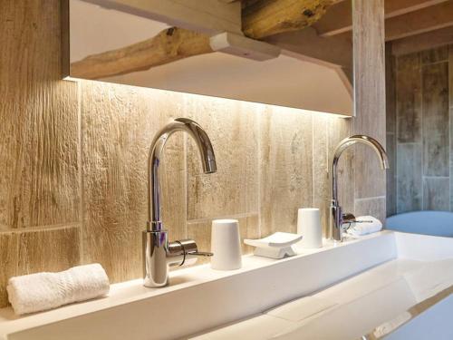 La salle de bains est pourvue de deux lavabos et de deux robinets. dans l'établissement Gite de luxe, à Groléjac