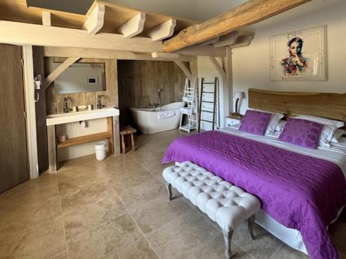 une chambre avec un lit, une baignoire et un lavabo dans l'établissement Gite de luxe, à Groléjac