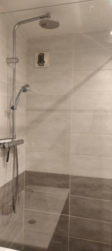 une douche avec une porte vitrée dans une salle de bain dans l'établissement A cozy bedroom in an apartment, à Villeurbanne