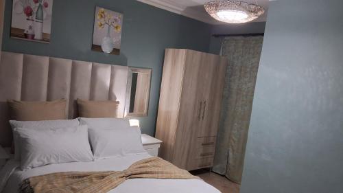a bedroom with a bed and a wooden cabinet at SIMICON Guesthouse in Witbank