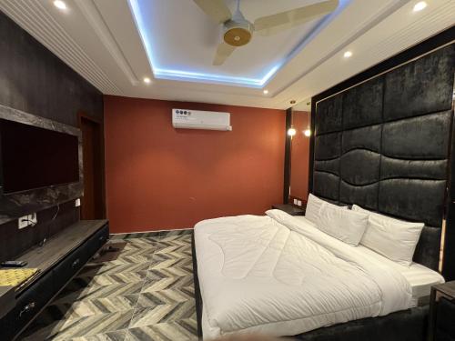 a bedroom with a large bed and a television at Courteous Hotel in Islamabad