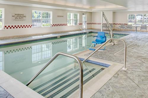 a swimming pool with a blue chair next to it at Residence Inn Boston Franklin in Franklin