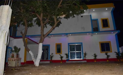 a house with a tree in front of it at TabTrips Laxmi Resort in Bāghmundi