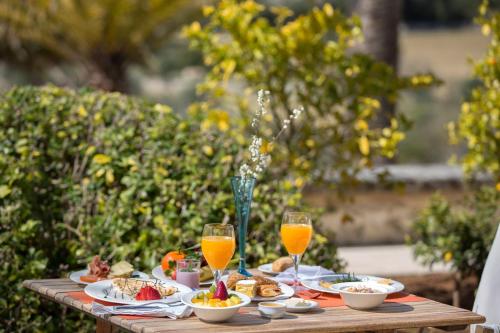 a table with plates of food and glasses of orange juice at Monnàber Vell in Campanet