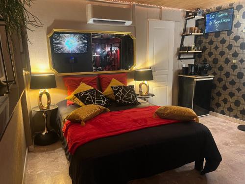 une chambre avec un grand lit avec des draps et des oreillers rouges dans l'établissement 50 Nuances de Parenthèses, à Nièvroz