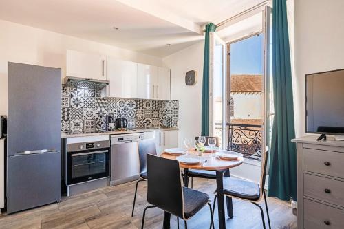 une cuisine avec une table et deux chaises ainsi qu'une salle à manger dans l'établissement Vue cathédrale - Hypercentre - Charme Historique, à Corbeil-Essonnes