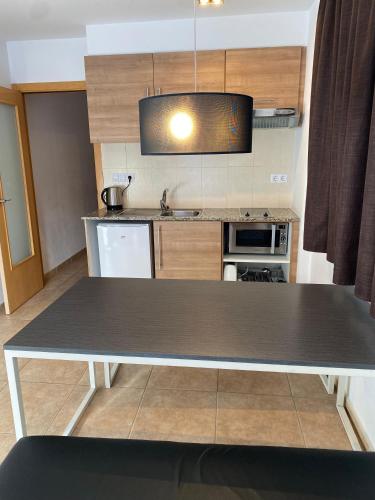 a kitchen with a table in the middle of it at Font del Ferro Apartments in El Tarter