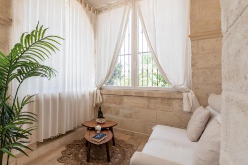 a living room with a white couch and a window at VILLA OSTUNI ONE mit Pool, Gästehaus & Glamping in Ostuni