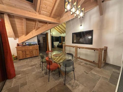 une salle à manger avec une table et des chaises en verre dans l'établissement Chalet 4 p Le Chardon du Roc, à La Côte dʼArbroz