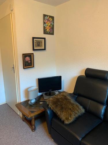 - un salon avec un canapé et une table avec un ordinateur dans l'établissement Studio des Ô Gentianes - 7 Laux, à Le Haut-Breda
