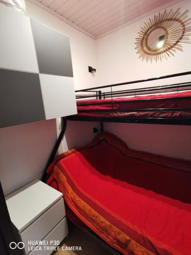 une chambre avec deux lits superposés et un miroir dans l'établissement T1 très fonctionnel résidence Tennis Village piscine, Ping Pong, citypark, boulodrome, au Cap d'Agde