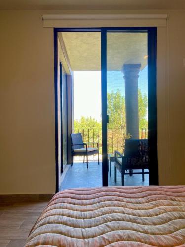a bedroom with a bed and a view of a balcony at EL Colibrí in San Miguel de Allende