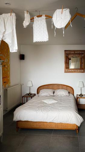 - une chambre avec un lit avec des draps blancs et 2 lampes dans l'établissement La Blanchisserie, à Mazé