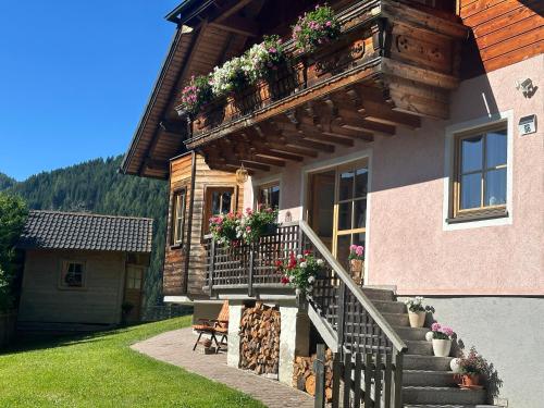 a house with a balcony with flowers on it at Apartments Schrim in Fiegler