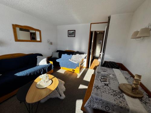 un salon avec un canapé bleu et une table dans l'établissement Studio 4 places Val Thorens, à Val Thorens