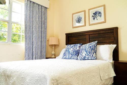 a bedroom with a bed with blue and white pillows at Kaye Devo Villa - Sixt Car Rental Partner in Choiseul
