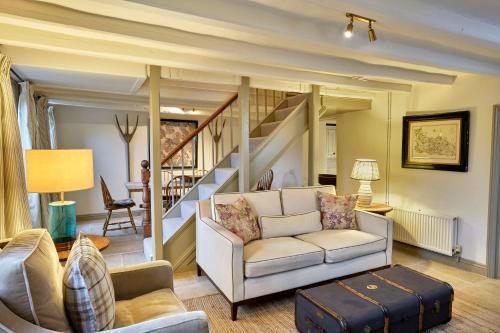 un soggiorno con un divano e una scala di Grints Cottage a Burnham Thorpe