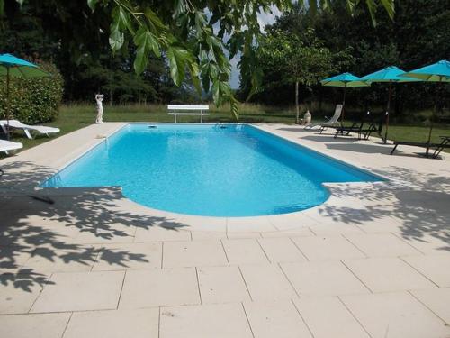 une piscine avec chaises et parasols dans une cour dans l'établissement Maison campagne avec piscine privée en Périgord, pour 6 personnes - FR-1-824-14, à Siorac-en-Périgord