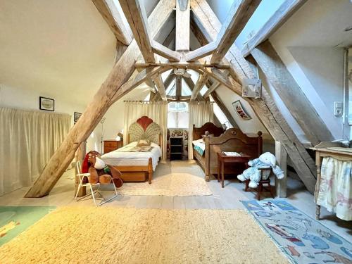 - une chambre mansardée avec un lit et des chaises dans l'établissement Maison campagne avec piscine privée en Périgord, pour 6 personnes - FR-1-824-14, à Siorac-en-Périgord